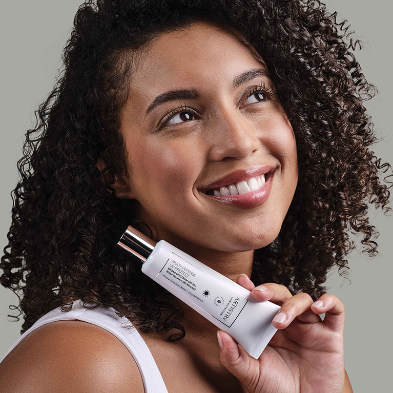 Woman holding Artistry Skin Nutrition™ Multi-Defense UV Protect SPF 50+