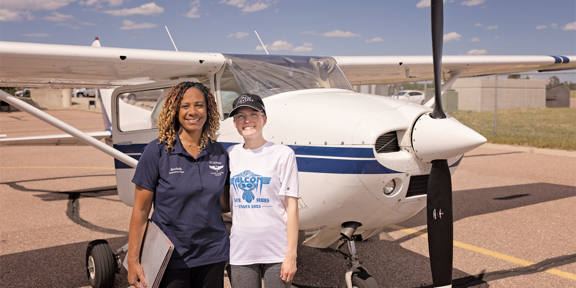 Rochelle Kimbrell poses in front of an airplane with a student she mentors.